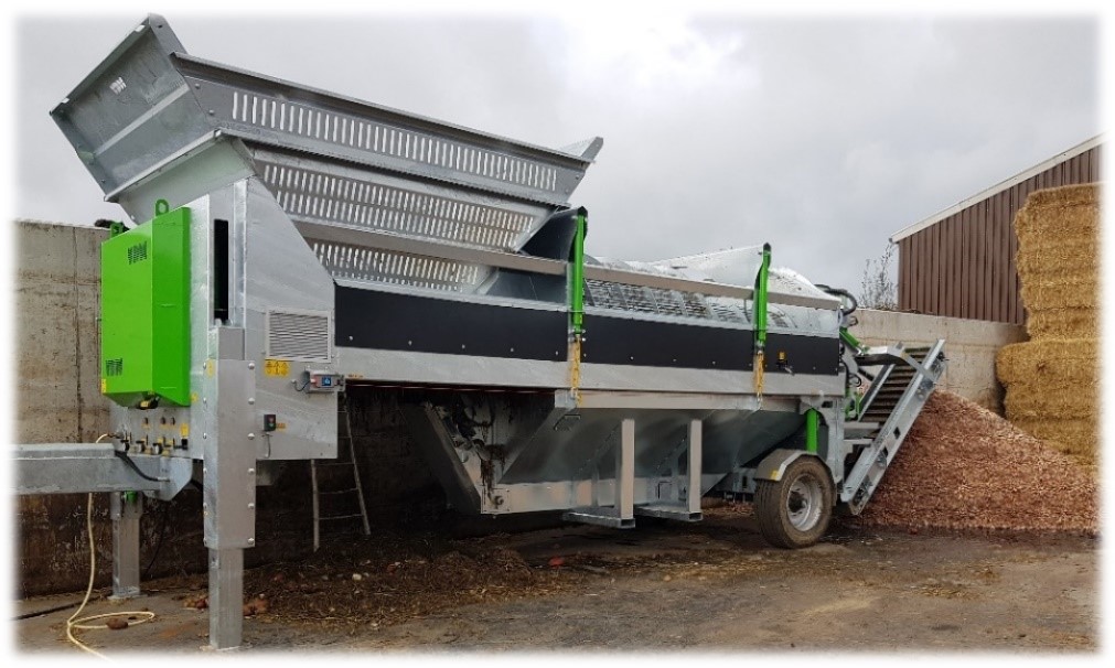 Mobile version of the ‘CLEANER TIGER AXIAL’ , whether homologated or not. The machine is driven by a pump group on power current 3x 380V. The 22kW electric motor drives a large and a small oil pump. Cleaning consists of part dry cleaning, and, in this case, optional wet cleaning. The dry cleaning consists of axial roller set, which transports the product to a large cleaning drum. The large cleaning drum rotates in a reservoir, through which the product is wet cleaned. Waste contained in the water is discharged through a special unloading belt with scrapers. To completely clean the reservoir in case of heavy contamination, it can be hydraulically lowered and removed on the telescopic handler's forks. This machine is equipped with a swivelling cutting cabinet (with optional stone protection) , allowing a choice of cutting the product or unloading it uncut onto the optional unloading belt. In this case, the machine is equipped with a 3m long unloading belt (optional), which is hydraulically swivelling and height-adjustable. The machine stands on hydraulically height-adjustable legs and wheel set. For long-term use, the machine is equipped with an oil cooler (option).